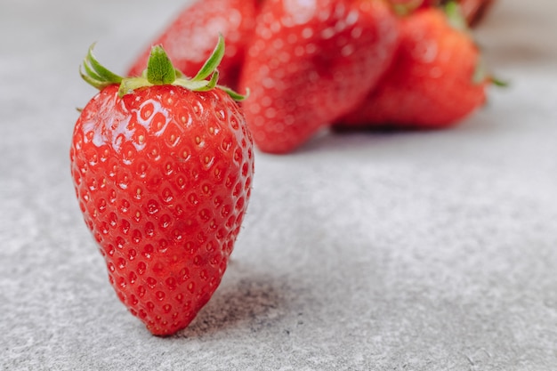 Juicy strawberries on a concrete background