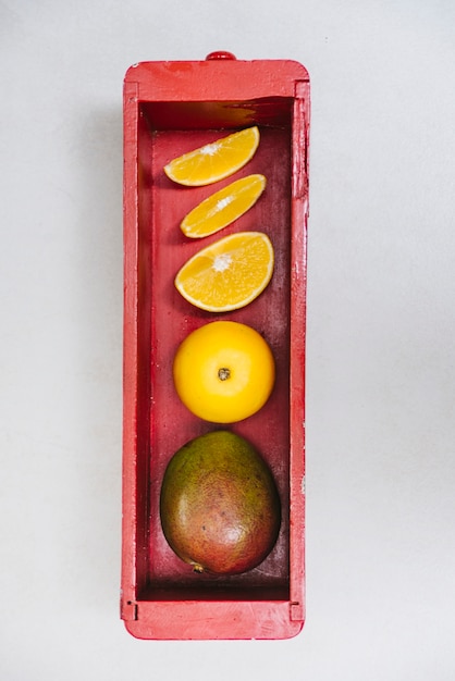 Free photo juicy sweet lime and mango in wooden container on white background