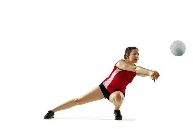 In jump and flight. Young female volleyball player isolated on white studio background. Woman in sportswear and sneakers training, playing. Concept of sport, healthy lifestyle, motion and movement.