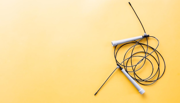 Free Photo jump rope on yellow icholized background flat lay