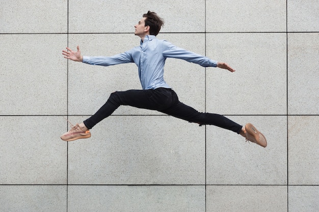 Free photo jumping office man in the city, ballet dancer