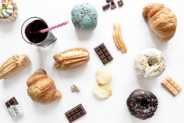 Free photo junk food with chocolate bar and cold drink isolated over white surface