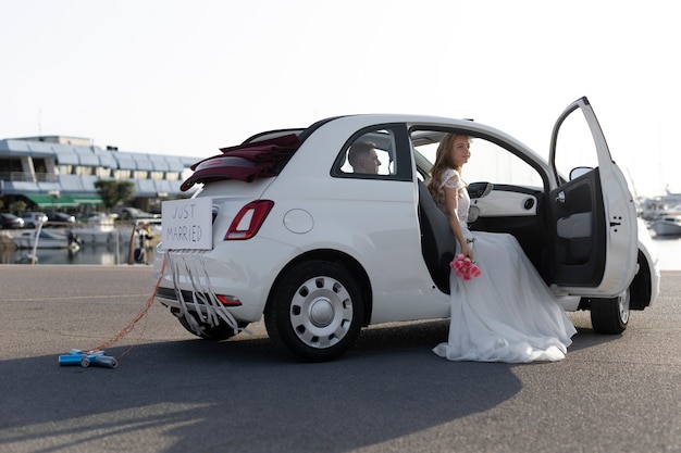 Just married couple inside little car