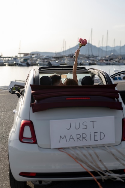 Just married couple inside little car