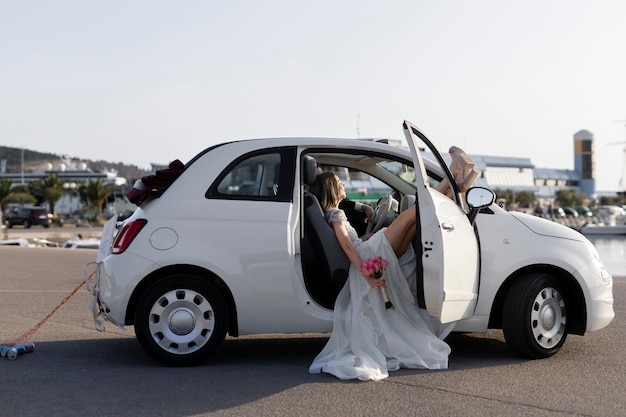 Just married couple inside little car