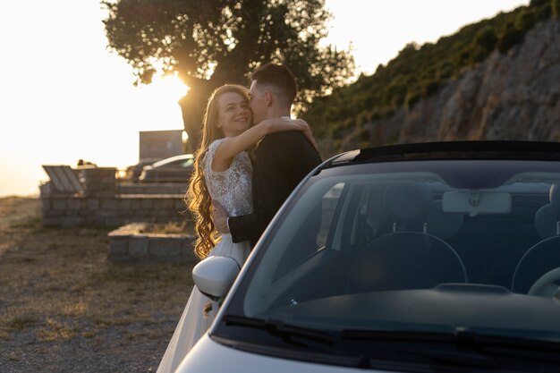 Free photo just married couple next to little car