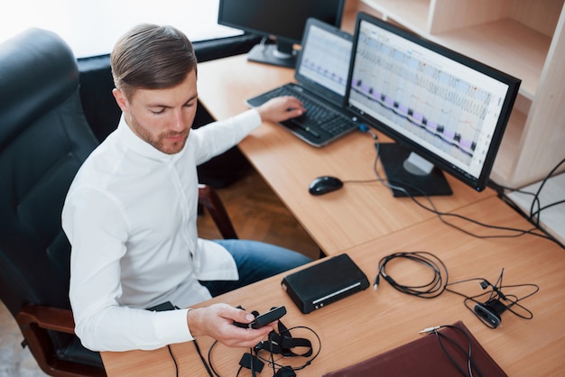 Free photo just a minute and we are ready. polygraph examiner works in the office with his lie detector's equipment