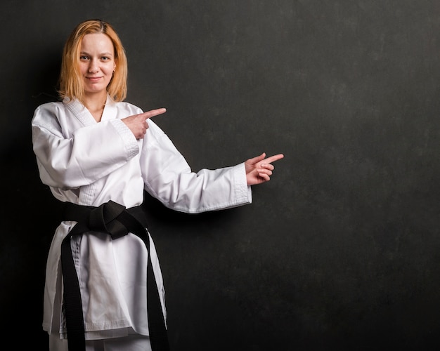 Free photo karate fighter pointing at copy space