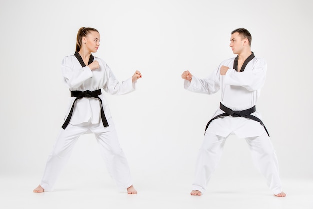 Free photo the karate girl and boy with black belts