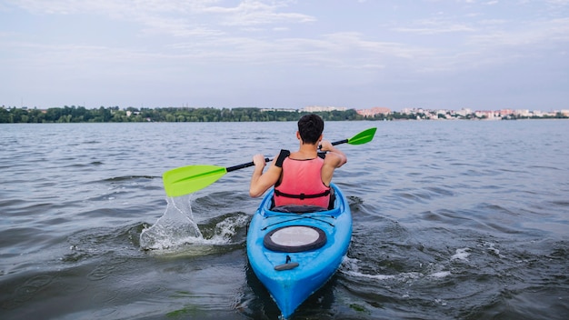 Kayaker splashing water with paddle while kayaking