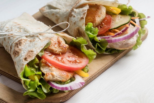 Kebab wrap with meat and vegetables on wooden board