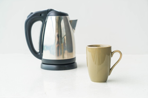 Free photo kettle and cup  on wall background