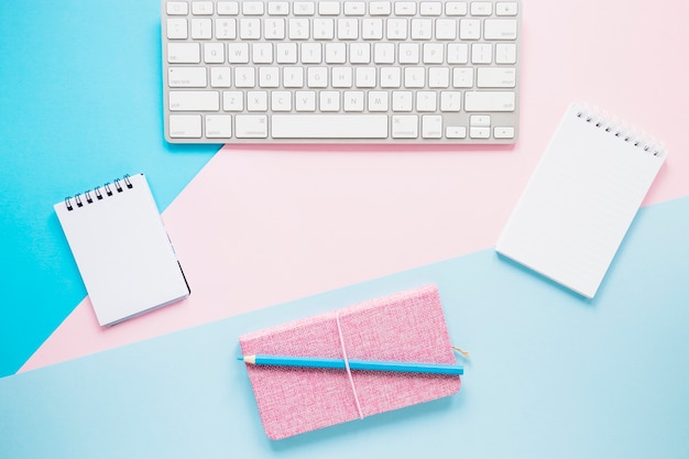 Keyboard and notebooks on cozy desktop