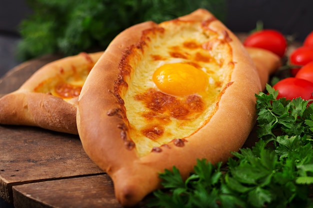 Khachapuri in Adjarian. Open pie with mozzarella and egg. Georgian cuisine.