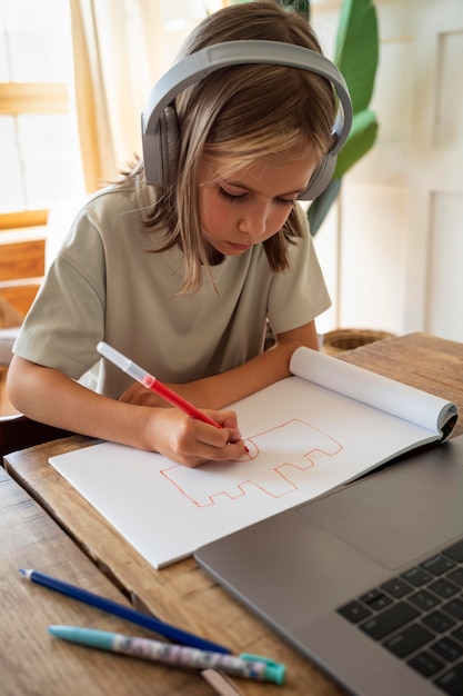 Free Photo kid drawing at home medium shot