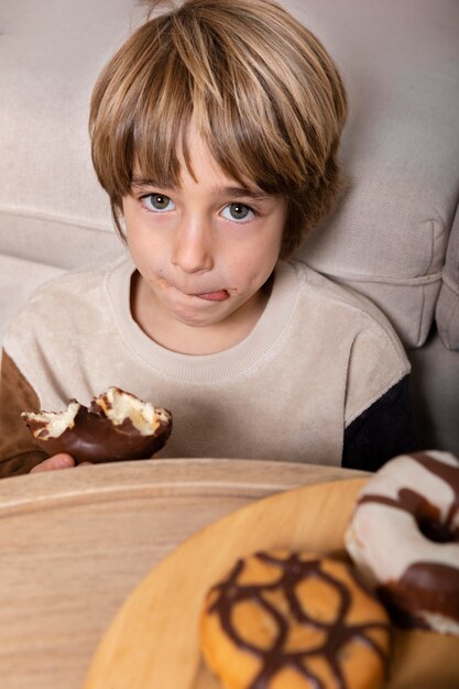 Kid eating doughnuts at home