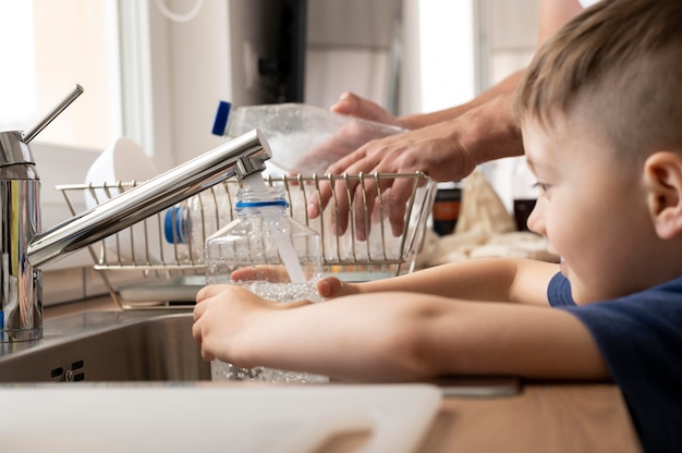 Free photo kid filling bottle with water