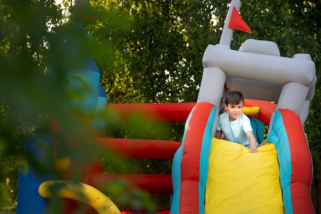 Free photo kid having fun in bounce house full shot