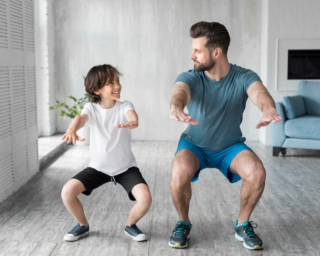 Kid and his father doing sport at home