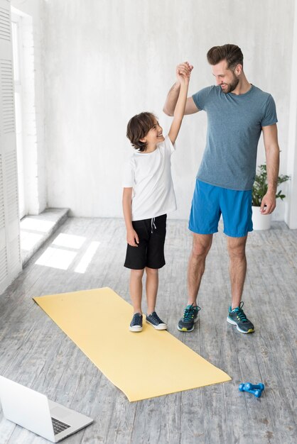 Kid and his father doing sport at home