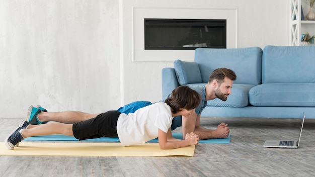 Kid and his father doing sport at home