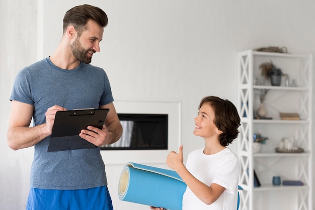 Free photo kid and his father doing sport at home