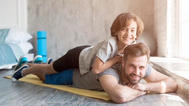 Free photo kid and his father doing sport at home