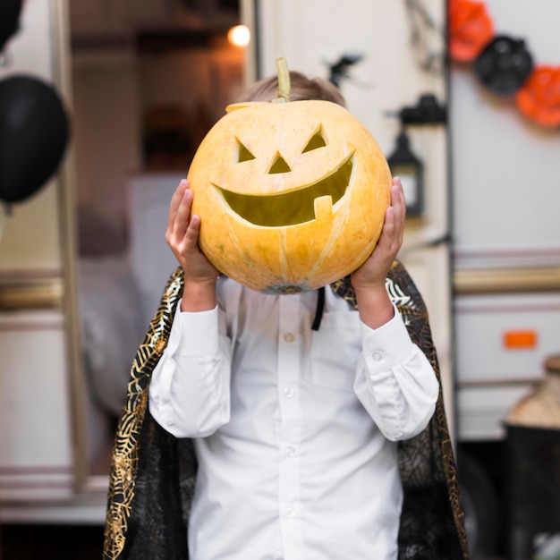 Kid holding carved pumpkin