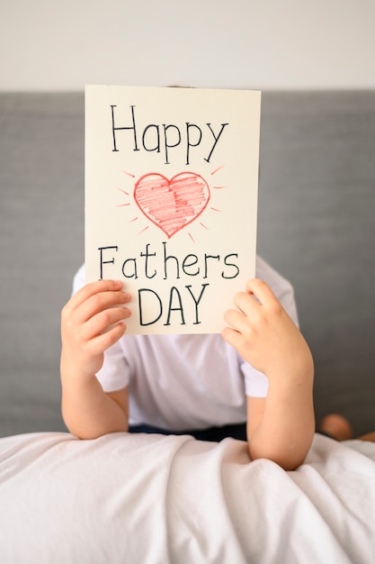 Free photo kid holding father's day greeting card