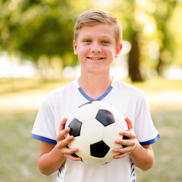 Kid holding a football outdoors