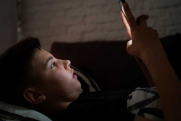 Kid holding smartphone side view