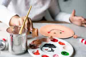 Free photo kid painting santa on a paper plate