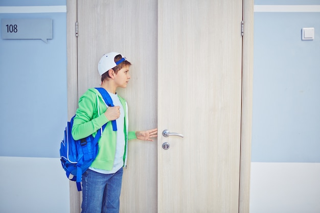 Kid peeking out through the door