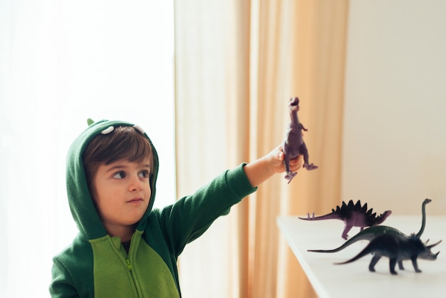 Free Photo kid playing with toy dinosaurs