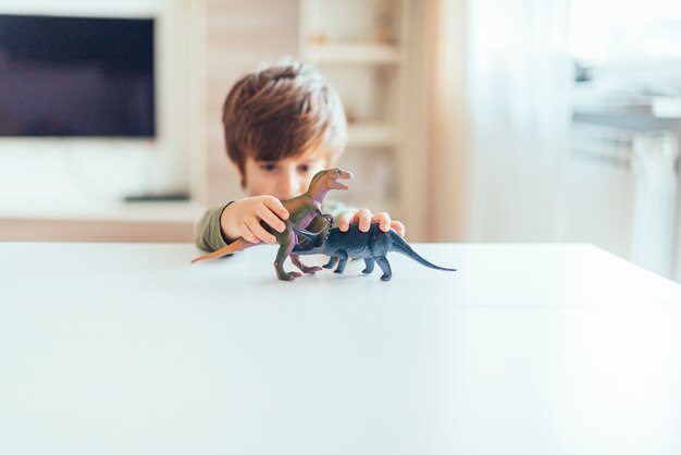 Kid playing with toy dinosaurs