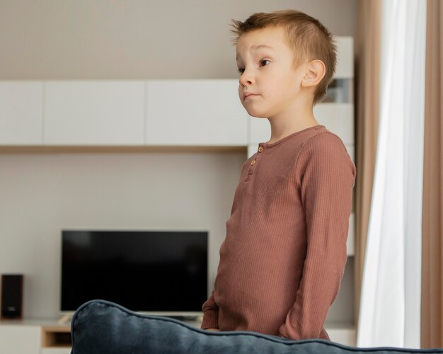 Kid standing on the sofa and looking away