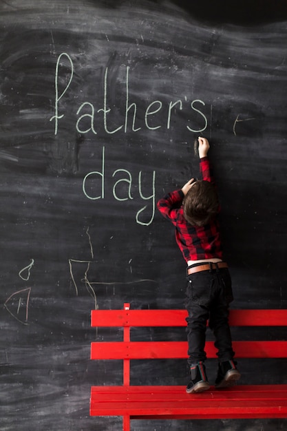 Free photo kid writing on blackboard