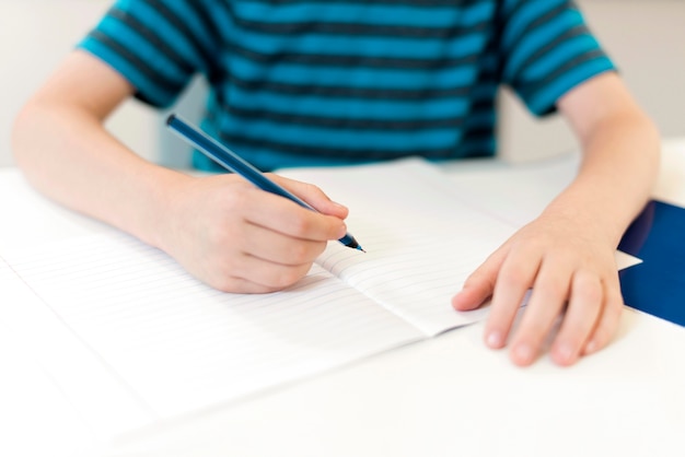 Kid writing on an empty notebook