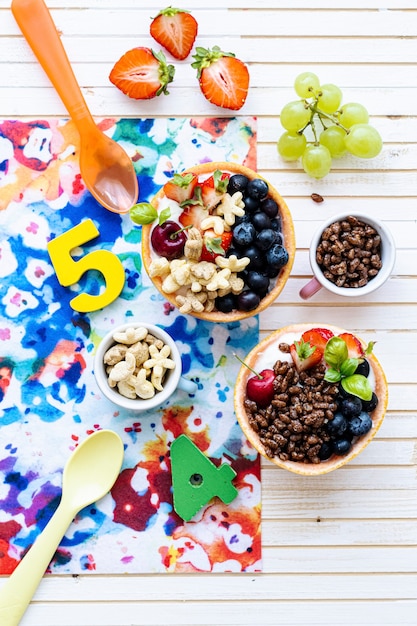 Kids birthday breakfast bowls with cereal and berries