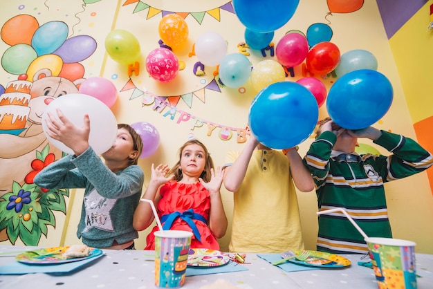 Kids blowing balloons during birthday celebration