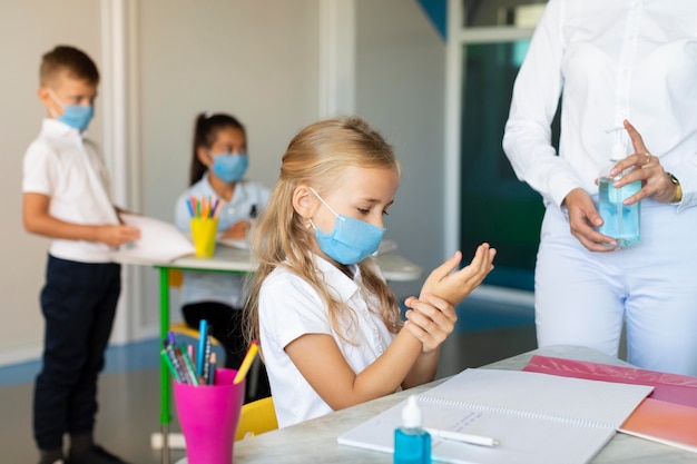 Kids disinfecting their hands before class