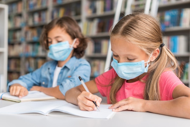 Kids doing homework while wearing face masks