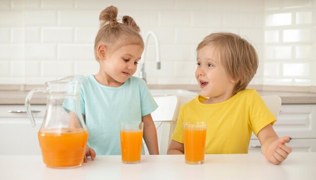 Free photo kids drinking juice at home