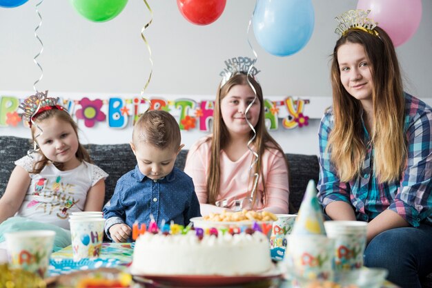 Kids enjoying birthday party near sweet table