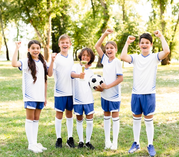 Kids in football equipment being enthusiasts about a new match