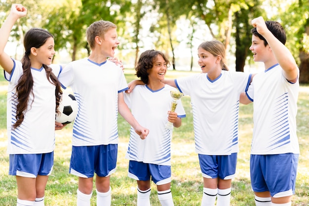 Free photo kids in football equipment getting ready for a match outdoors