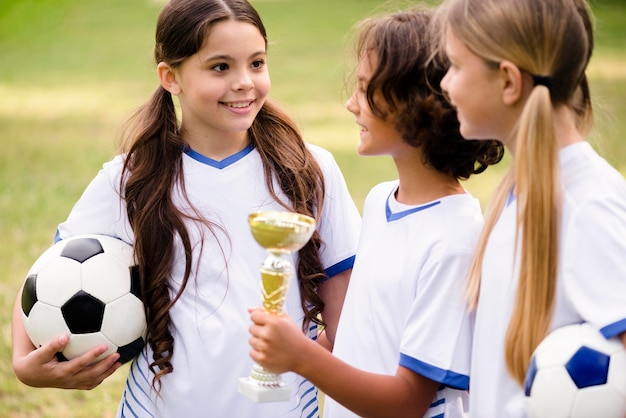 Kids getting a trophy after winning a football match