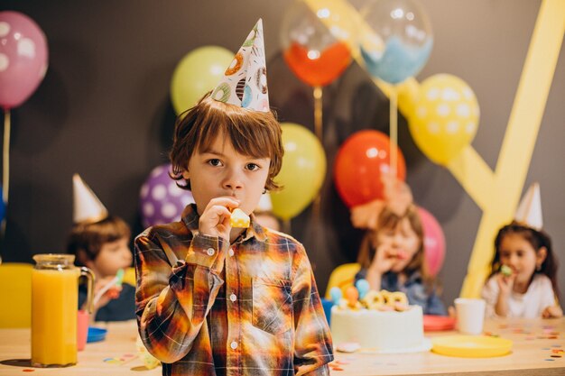 Kids having fun at birthday party with balloons and cake