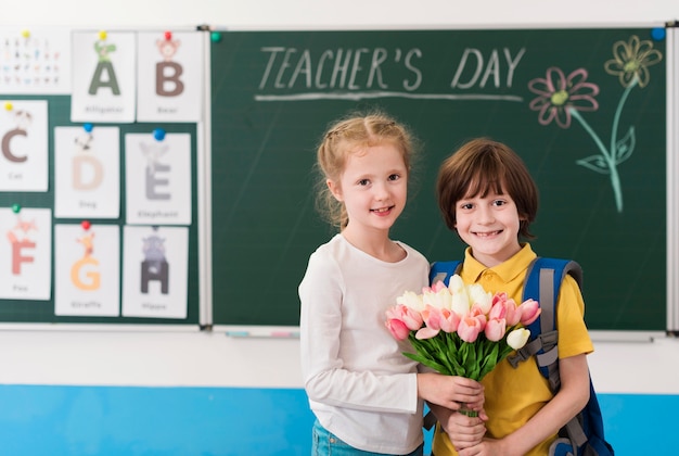 Free photo kids holding together a bouquet of flowers for their teacher