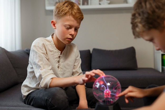 Free photo kids interacting with a plasma ball